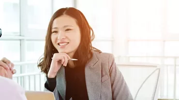 Two people having a conversation in a bright office.