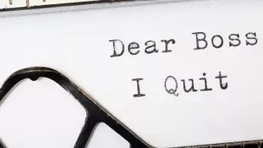 Typewriter with text 'Dear Boss, I Quit' on paper.