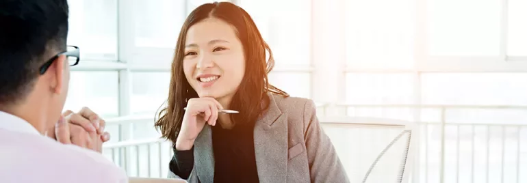 Two people having a conversation in a bright office.