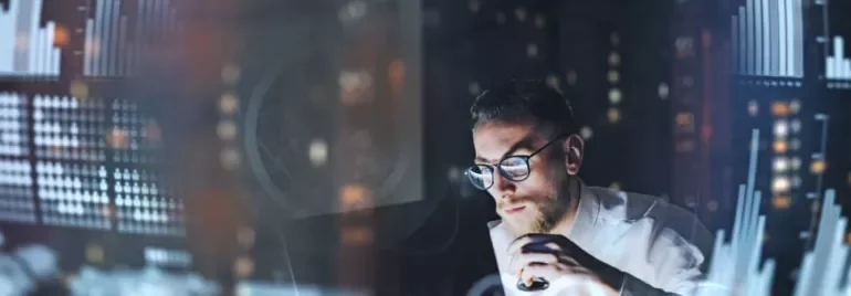 Man analyzing data charts on a computer screen.