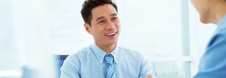 Two professionals having a conversation in a bright office setting.