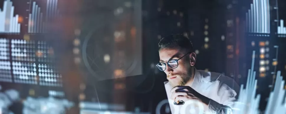 Man analyzing data charts on a computer screen.