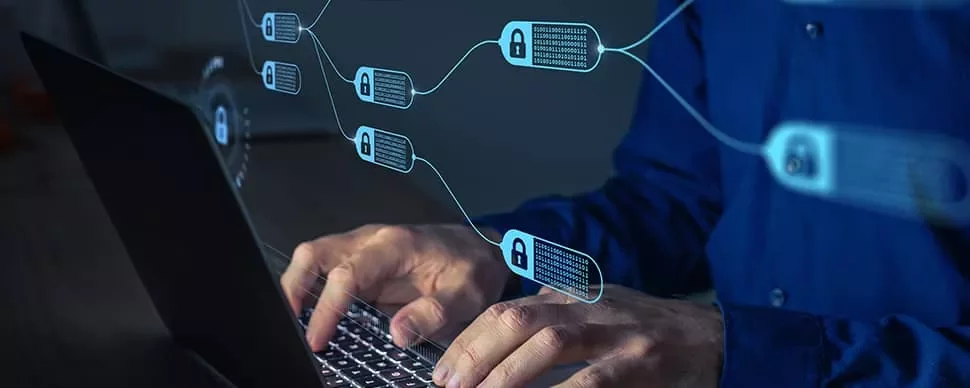 Person typing on a laptop with a visual representation of a blockchain network.