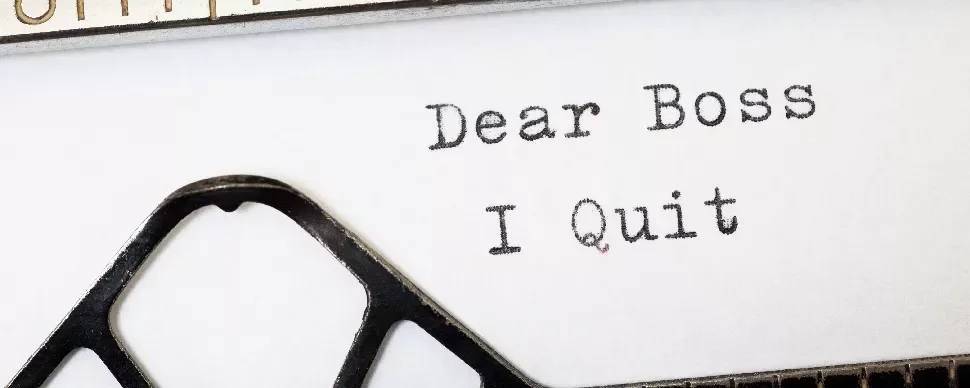 Typewriter with text 'Dear Boss, I Quit' on paper.