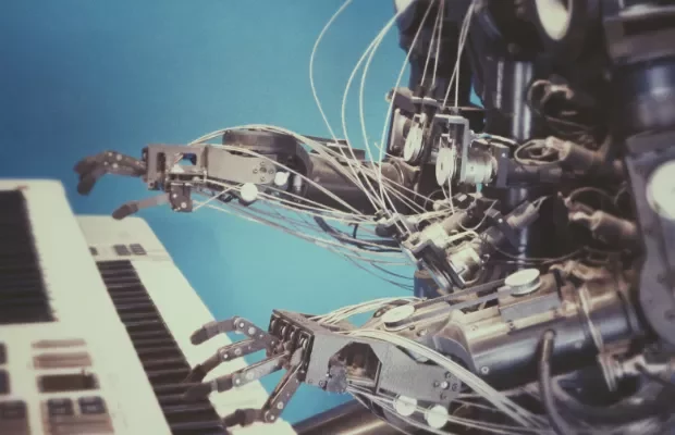 Robotic arms playing a keyboard.
