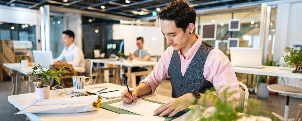 male working professional with hearing aid at a workdesk