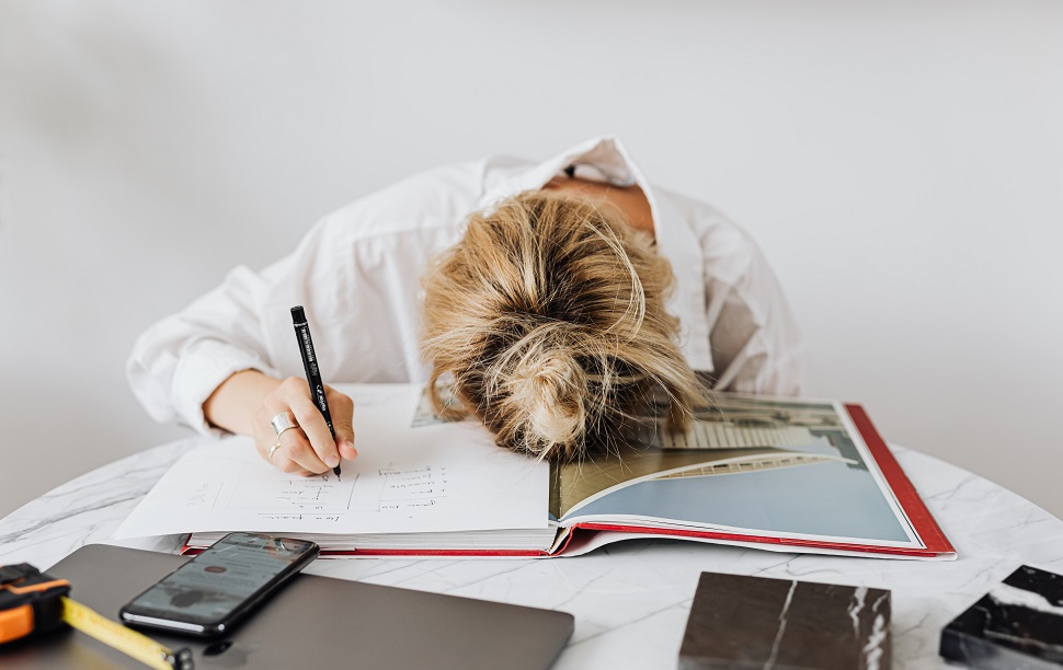 A female worker with her head on the desk, looking like she fell asleep while working